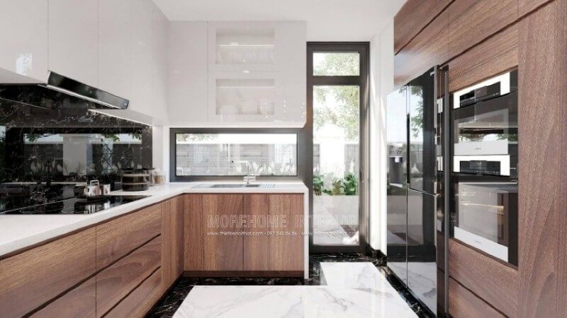 Với cách trang trí nội thất độc đáo, mẫu phòng bếp hiện đại trong đây sẽ là một ý tưởng tuyệt vời cho các không gian như nhà phố có sân vườn, biệt thự,.. Lối đi ra ngoài sân vườn, bạn có thể tận dụng trồng những cây rau thơm, gia vị; cánh cửa kính trắng giúp bạn có thể vừa nấu ăn vừa quan sát hoạt động ngoài trời của con.